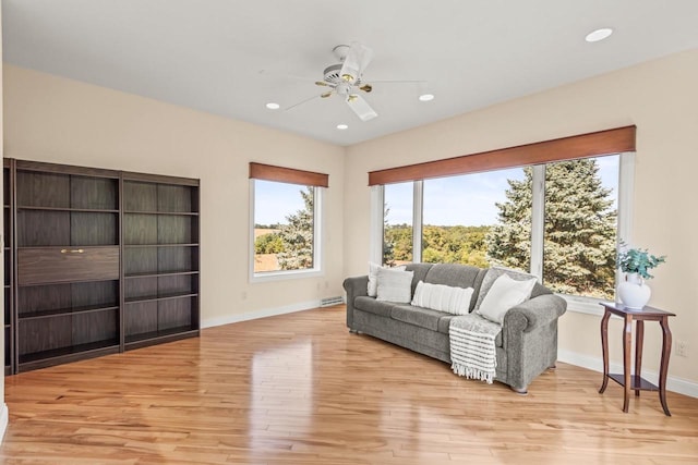 living room with ceiling fan and light hardwood / wood-style flooring