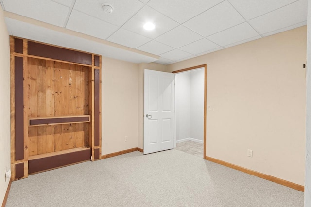 unfurnished bedroom with carpet floors, a drop ceiling, and a closet