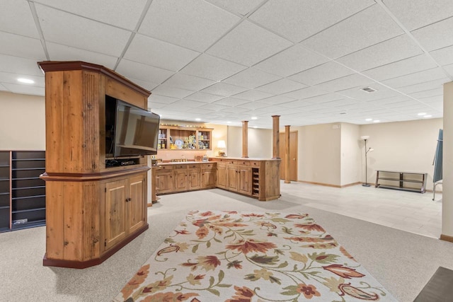 living room featuring light colored carpet, a drop ceiling, and bar