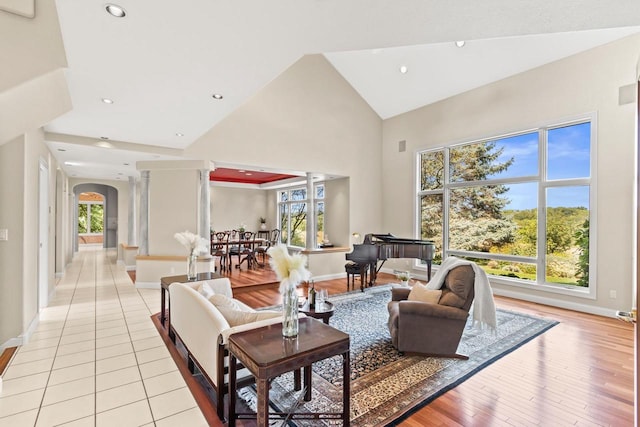 living room featuring light hardwood / wood-style flooring, a wealth of natural light, and high vaulted ceiling