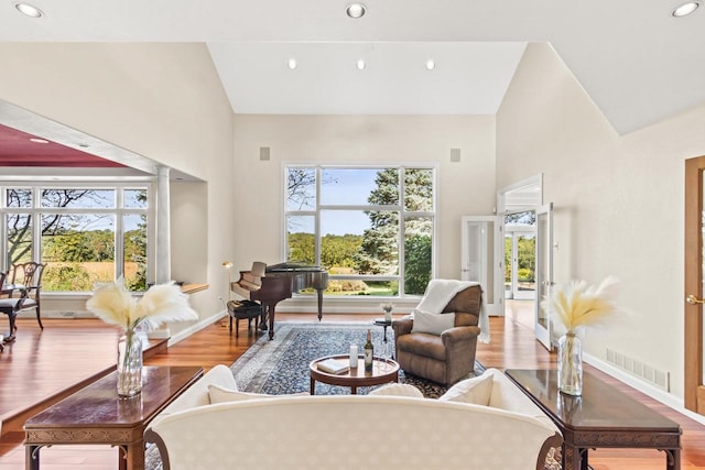 living room featuring light hardwood / wood-style flooring and high vaulted ceiling