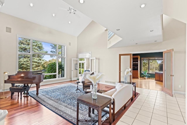 living room with ceiling fan, high vaulted ceiling, and a healthy amount of sunlight