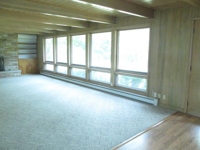 unfurnished room featuring wood ceiling, a healthy amount of sunlight, and a fireplace