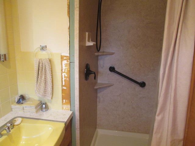 bathroom featuring a shower with shower curtain and vanity