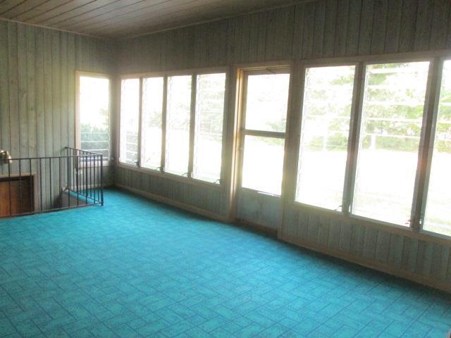 unfurnished sunroom with wood ceiling and plenty of natural light