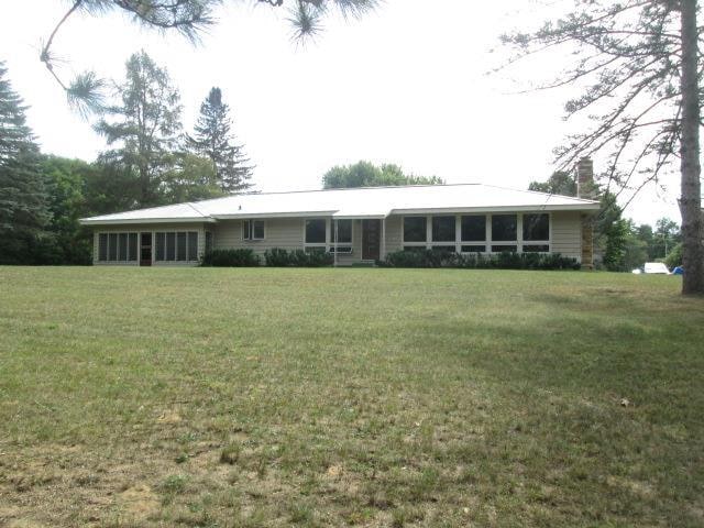 rear view of house featuring a yard