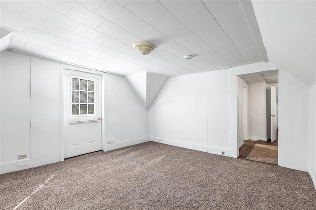 bonus room with vaulted ceiling and carpet floors