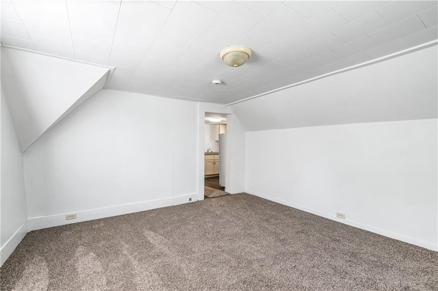 additional living space with carpet floors, baseboards, and lofted ceiling
