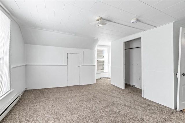 unfurnished room with carpet, vaulted ceiling, and baseboard heating