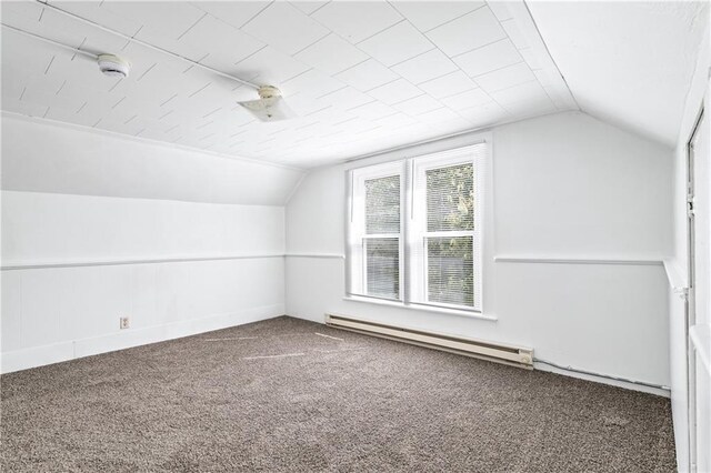 additional living space with carpet, vaulted ceiling, and a baseboard heating unit