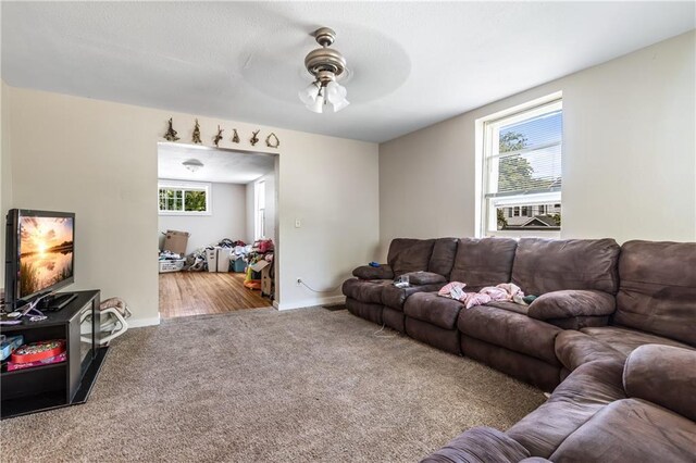 carpeted living room with ceiling fan and plenty of natural light