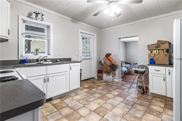 kitchen with white cabinets, white fridge, crown molding, ceiling fan, and sink