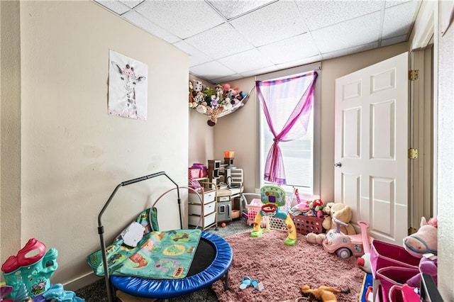 game room with carpet floors and a paneled ceiling