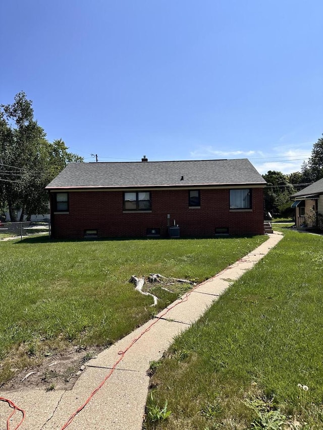 rear view of house featuring a lawn