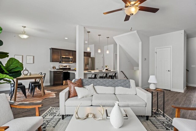 living room with dark wood-type flooring and ceiling fan