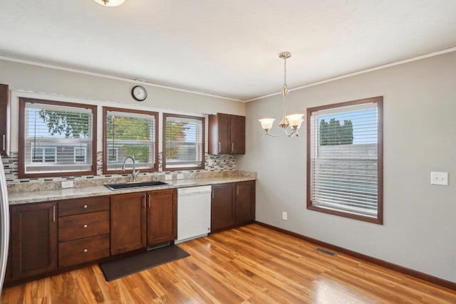 kitchen featuring plenty of natural light, hanging light fixtures, sink, and white dishwasher