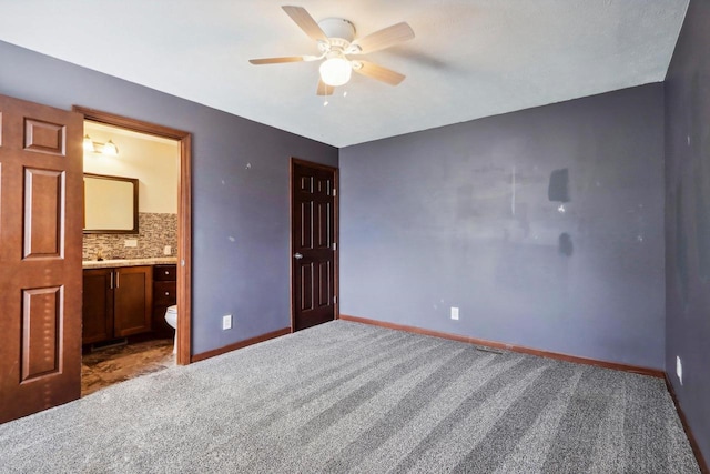 unfurnished bedroom with carpet, connected bathroom, and ceiling fan