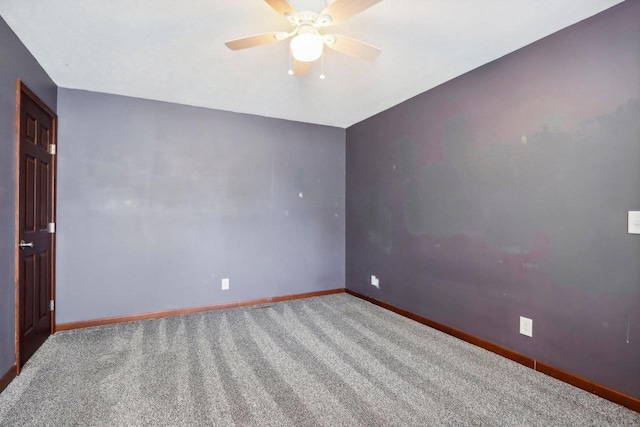 carpeted spare room with ceiling fan