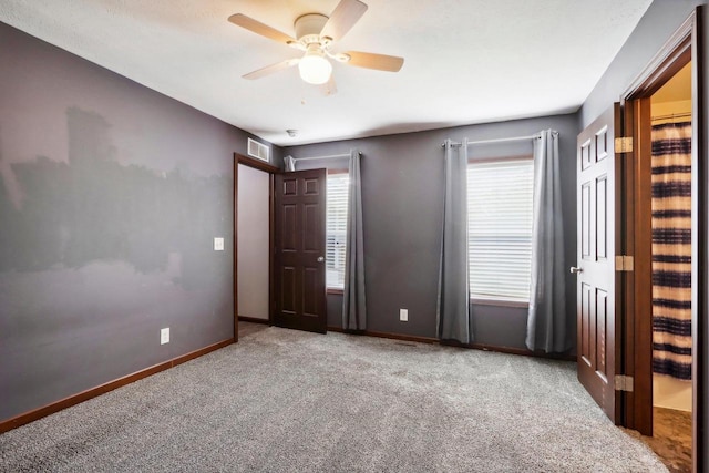 unfurnished bedroom with light colored carpet and ceiling fan