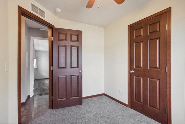 interior space featuring ceiling fan and dark carpet