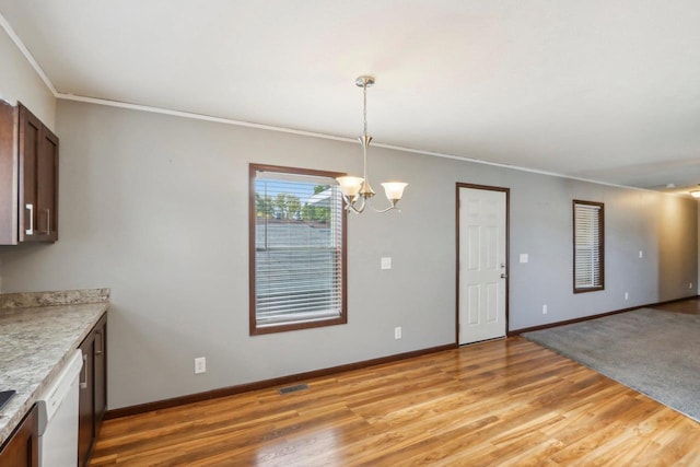 interior space featuring light wood-type flooring, pendant lighting, crown molding, a notable chandelier, and dishwasher