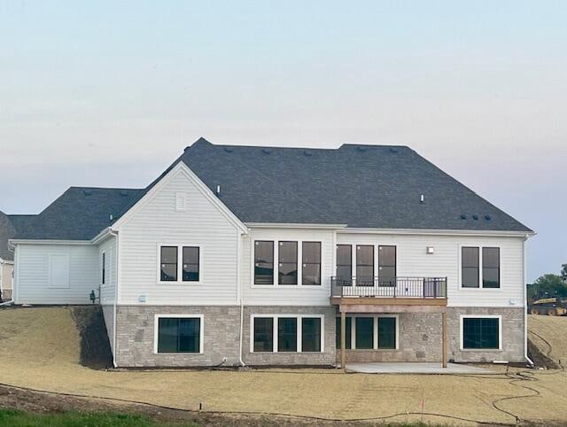 back of house with a balcony, a yard, and a patio