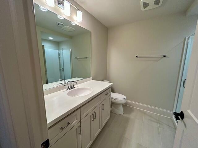 bathroom featuring vanity, a shower with shower door, and toilet