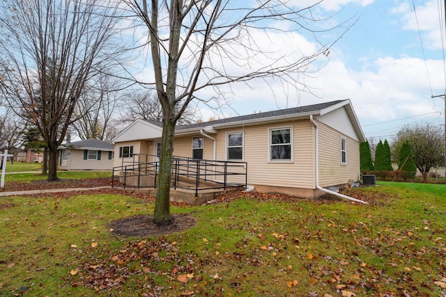 view of front of house with a front yard and cooling unit