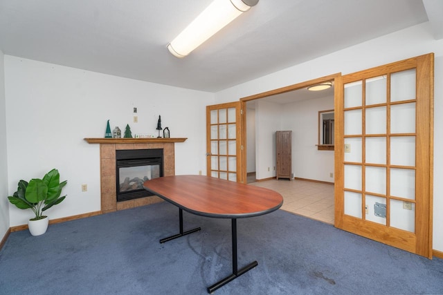 carpeted home office with a multi sided fireplace and french doors