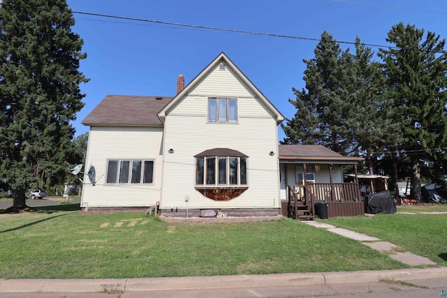 view of front of home with a front yard and a wooden deck