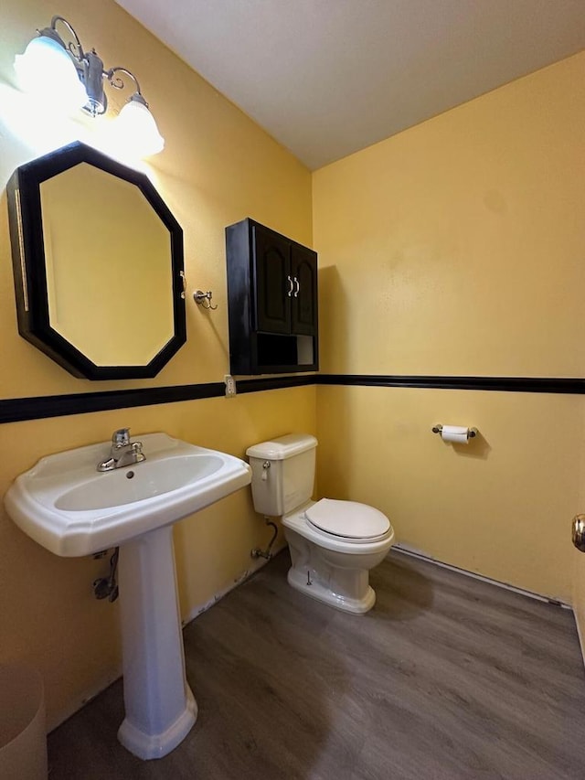 bathroom with hardwood / wood-style flooring, toilet, and sink