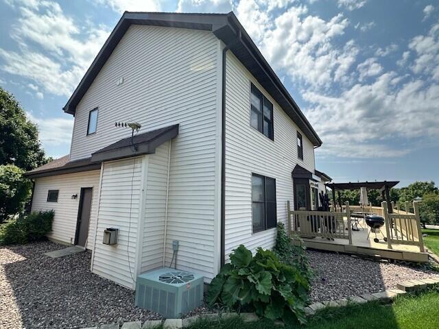 rear view of house featuring a wooden deck, central AC, and a pergola