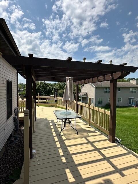 wooden deck with a pergola and a lawn