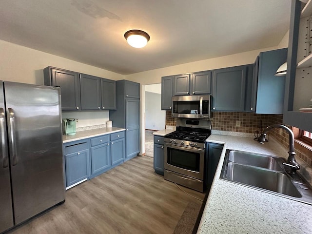 kitchen featuring decorative backsplash, hardwood / wood-style floors, appliances with stainless steel finishes, and sink