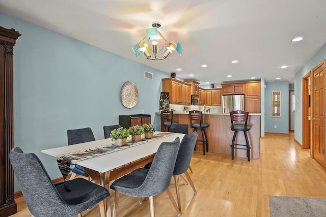 dining room featuring a chandelier and light wood-type flooring