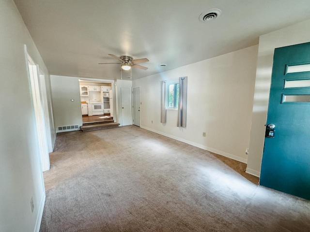 unfurnished living room with carpet and ceiling fan