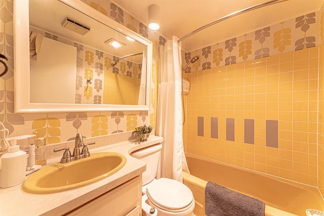 full bathroom featuring shower / bath combination with curtain, toilet, decorative backsplash, vanity, and tile walls