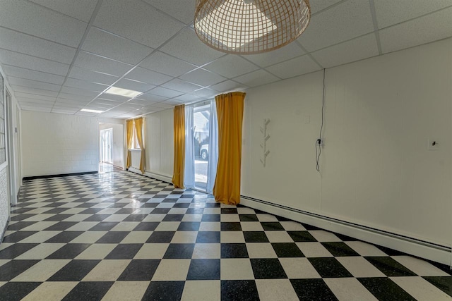 spare room featuring a drop ceiling and baseboard heating