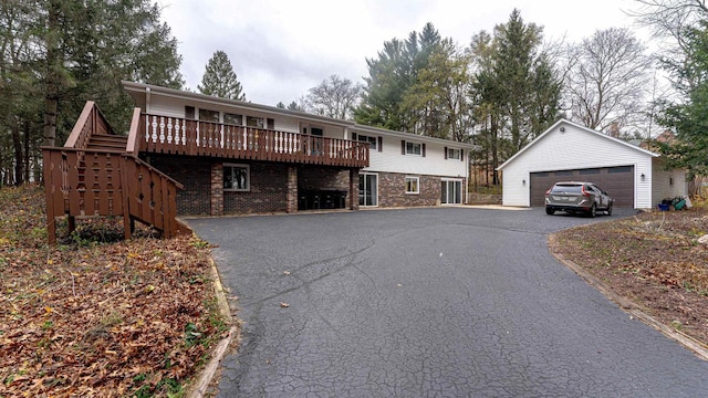 view of front of property featuring a garage, an outdoor structure, and a wooden deck