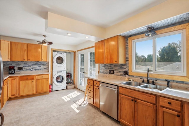 kitchen with stacked washer and clothes dryer, stainless steel dishwasher, ceiling fan, and plenty of natural light