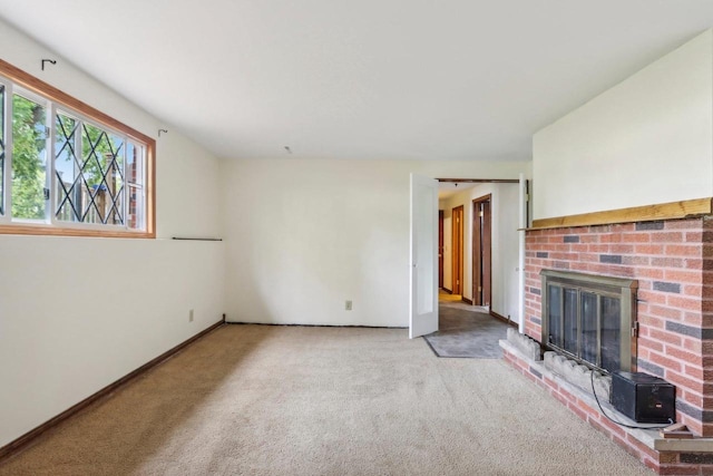 unfurnished living room featuring a brick fireplace and light colored carpet