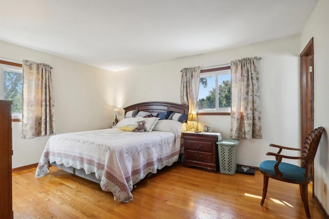 bedroom with multiple windows and light hardwood / wood-style flooring