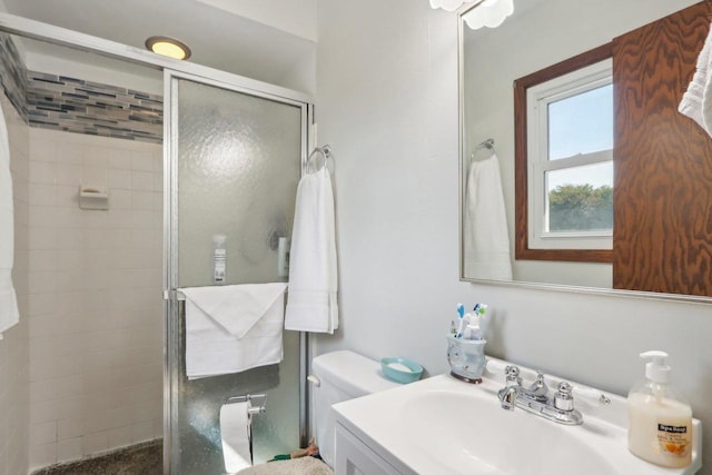 bathroom with vanity, toilet, and a shower with shower door