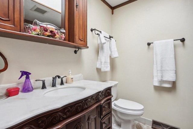 bathroom featuring toilet, vanity, and crown molding