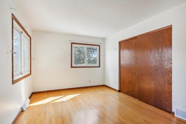 unfurnished bedroom featuring light wood-type flooring and a closet