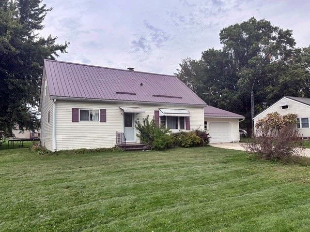 rear view of house with a lawn and a garage