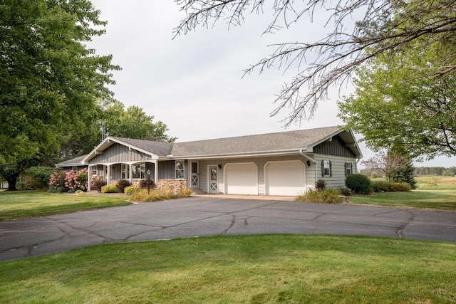 ranch-style house featuring a garage and a front lawn