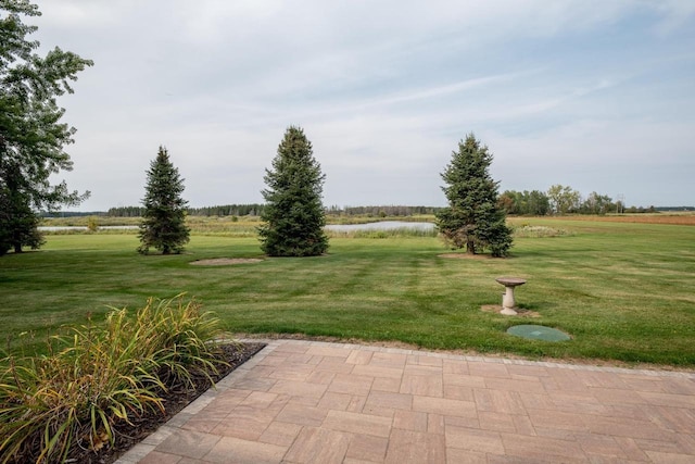 view of community featuring a water view, a yard, and a patio area