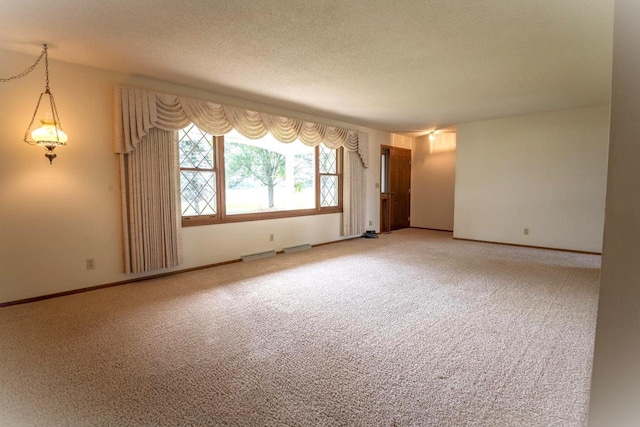 unfurnished room featuring a textured ceiling and carpet