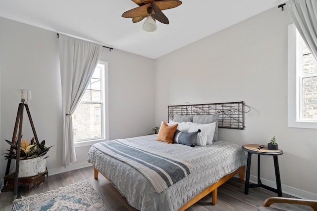 bedroom with hardwood / wood-style floors, multiple windows, and ceiling fan